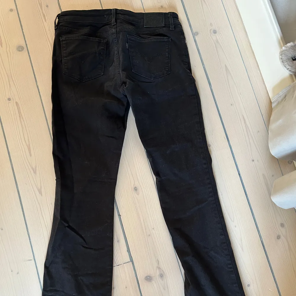 Snygga svarta bootcut jeans med klassisk femficksdesign. Perfekta för en stilren look. De har en knapp- och dragkedjestängning framtill.. Farkut & Housut.