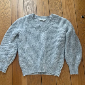 Grå ribbad stickad tröja - En grå stickad tröja .