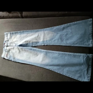 Ljusblå bootcut jeans - Snygga ljusblå bootcut jeans med klassisk femficksdesign. Tillverkade av 95% bomull och 5% syntet för en bekväm passform. Perfekta för en avslappnad stil. MÅTT: midjemått-34cm, länd-85cm