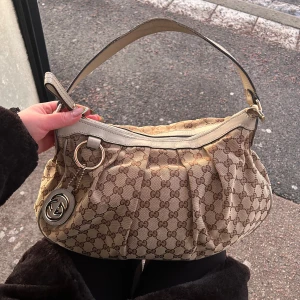 Gucci sukey hobo bag - Kollar nu intresset på min fina Gucci väska. Den är köpt från Vintage by Ebba, och original dustbag finns med. Inget mer äkthetsbevis än att hon endast säljer äkta väskor mm. Den är av mig varsamt använd men har lite skavanker då den är vintage. Finns en lite mer synlig fläck på baksidan men har själv inte försökt få bort då jag inte ville förstöra väskan. (Fläcken fanns när jag köpte). Jag köpte för ca 4000kr. Skriv gärna om ni är intresserade, vill ha mer bilder eller så! 