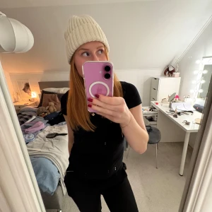 Cremevit stickad mössa - Snygg vit stickad mössa som passar perfekt för kyliga dagar. Den har en ribbad design som ger en stilren look. Perfekt för både höst och vinter!