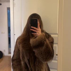 Brun pälsjacka - Säljer en lyxig brun pälsjacka med långärmad design. Perfekt för att hålla sig varm och stilren under kyliga dagar. 