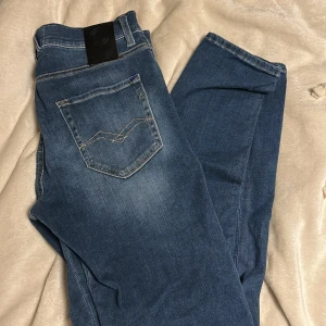 Blå Replay jeans - Stilrena Replayjeans med skön slim passform. Jeansen är i storlek 29W 30L.