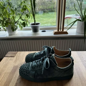 Christian Louboutin skor - Snygga gröna sneakers från Christian Louboutin med nitar. Nästan helt nya och bara använd fåtal gånger, därav priset. Storlek 45 och passar som 44-45 Skriv för fler bilder. 