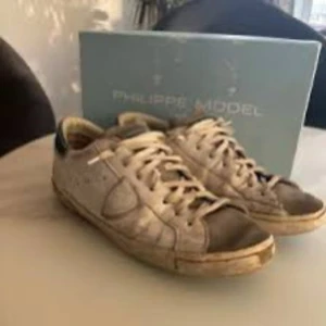 Vita sneakers från Philippe Model - Snygga vita sneakers från Philippe Model med klassisk design och snörning. Skorna har en stilren look med en touch av vintage känsla. Perfekta för en avslappnad stil.