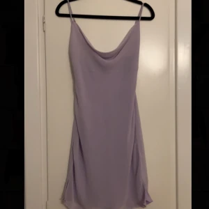 Ljuslila klänning  - Säljer en stilren ljuslila klänning från Urban Outfitters. Klänningen har tunna axelband och en elegant draperad halslinje. Perfekt för en somrig look eller en utekväll. 💜