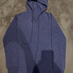 Blå kashmir hoodie - Säljer en stilren blå kashmir hoodie perfekt för en avslappnad look. Skick 10/10