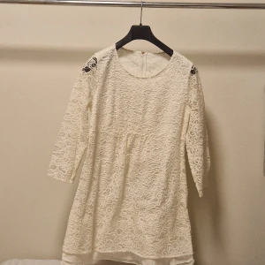 Vit spetsklänning - Charmig vit spetsklänning med trekvartsärm och ett vackert blommönster 🌸🌸 Den har dragkredja där bak. Lappen är borta så vet inte storlek men skulle säga s. Perfekt för vår och sommar eller som studentklänning! 🍾 Bara att skriva om ni har frågor 💗