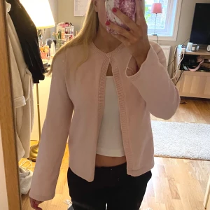 Rosa kofta från Gina tricot - Säljer en söt rosa kofta från Gina Tricot. Den har en enkel design med rund halsringning och en knapp framtill. Knappt använd storlek S