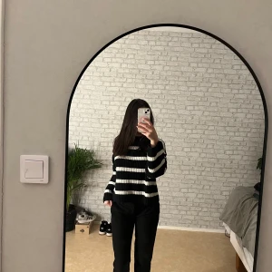 Svart och vit randig stickad tröja från Ivy - Säljer en snygg svart och vit randig stickad tröja från Ivy. Tröjan har en klassisk design med långa ärmar och en bekväm passform. Perfekt för att hålla sig varm och stilren under kyligare dagar. Hör av dig vid intresse!