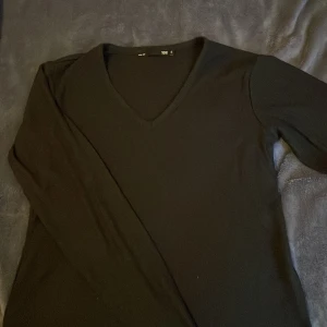 Svart långärmad tröja från lager 157 - Säljer en stilren svart långärmad tröja från lager 157. Tröjan har en v-ringad hals och är perfekt för en enkel och klassisk look. Passar bra till både jeans och kjol. Perfekt för höst och vinter!