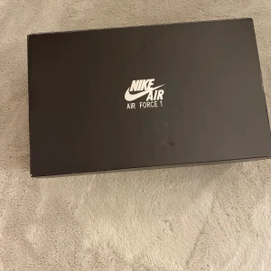 Vita Nike Air Force 1 - Säljer ett par klassiska vita Nike Air Force 1 sneakers. Skorna har en stilren design med snörning och en bekväm sula. Perfekta för en avslappnad och trendig look. Nypris: 1649kr
