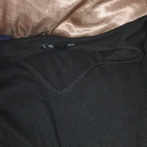 Svart ribbad tröja från hm - Säljer en stilren svart ribbad tröja från hm. Tröjan har en v-ringad hals och är perfekt för en minimalistisk look. Passar bra till både jeans och kjol. Perfekt för höst och vinter!