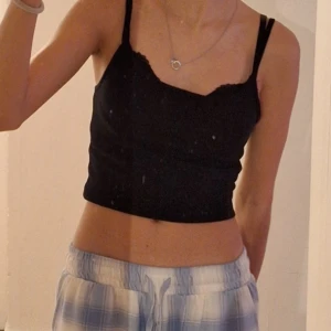 Svart croppad linnetopp - Säljer en stilren svart croppad linnetopp med smala axelband. Är i storlek XS. Säljer då jag inte använder den🩷