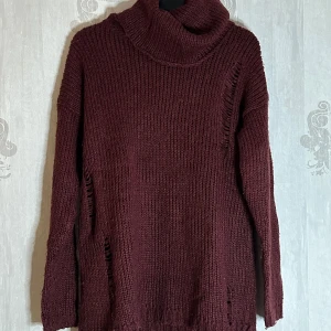 Vinröd stickad polotröja från Gina Tricot - Säljer en mysig vinröd stickad polotröja från Gina Tricot. Tröjan har långa ärmar och en avslappnad passform med dekorativa slitningar. Perfekt för kyliga dagar!