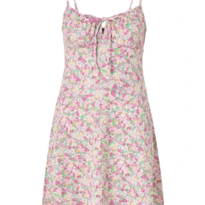 Blommig klänning från Gina Tricot - Söt blommig klänning från Gina Tricot i storlek XXS. Klänningen har smala axelband och en knytning framtill. Perfekt för sommarens varma dagar med sitt färgglada mönster i rosa, grönt och gult🩷💚💛