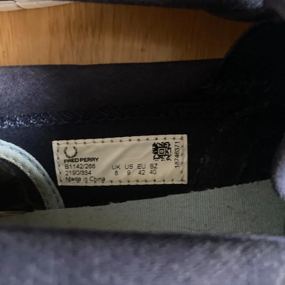 Säljer ett par stilrena blå slip-on skor från Fred Perry. Skorna har en vit sula och är perfekta för en avslappnad stil. De är lätta att ta på och av, vilket gör dem praktiska för vardagsbruk.. Kengät.