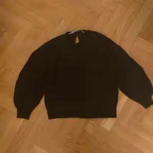 Säljer en stilren svart tröja från The Black Label Collection. Tröjan har en unik detalj med en liten öppning bak i nacken. Perfekt för en minimalistisk look.