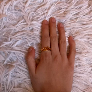 Guldfärgad ring med text - Trendig guldfärgad ring med ordet 'kiss' i en stilren design. Perfekt för att ge en personlig touch till din stil. Passar bra på både fest och vardag.