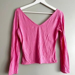 Rosa långärmad topp - Säljer en söt rosa långärmad topp med v-ringning. Perfekt för både vardag och fest! Toppen är i ett mjukt och bekvämt material som känns skönt mot huden. Passar bra till jeans eller kjol för en avslappnad look.