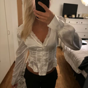 Vit siden topp - En superfin korsett liknande blus i siden. Endast använd 1 gång och är i nyskick. Inköpt för över ett år sedan så den säljs inte längre. Säljer då den inte kommer till användning. 🫶🏼Tryck inte på köp direkt! 