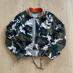 Kammoflage jacka - Väldigt söt kammoflage jacka med volanger, köpt på weekdays secondhand för ca 900. Säljer pga att den är lite för kort på mig (jae 180), annars är den knappt använd och i jättebra skick, medela om frågor. Diskuterbart pris.