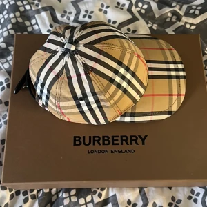 Burberry keps  - Burberry keps köpt från burberrys hemsida kvitto box och allt med följer. Kepsen är knappt använd och är i nyskick. Inga fel eller  liknande finns. Skriv vid intresse, storlek S 