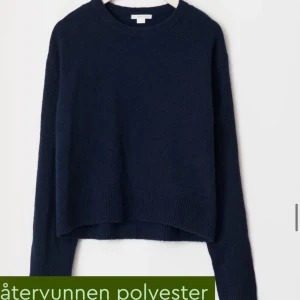 Mörkblå tröja i återvunnen polyester - Säljer en stilren mörkblå tröja i återvunnen polyester. Tröjan har en klassisk rund hals och långa ärmar, perfekt för kyligare dagar. Den är enkel att matcha med olika outfits och ett hållbart val för garderoben. 