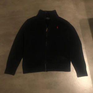 Marinblå stickad tröja från Polo Ralph Lauren - Stickad Ralph lauren zip. Använd men är i fantastiskt skick. Något blekt men inget man märker. Storlek :14-16 vilket är ungefär XS. Har ni frågor eller liknande är det bara att höra av sig😊