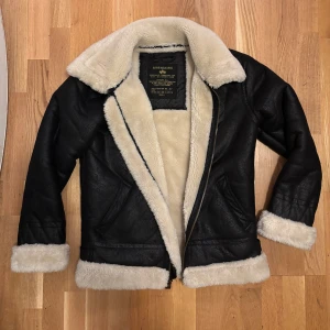 Alpha Industries pilotjacka  -  svart skinnjacka från Alpha Industries med mjukt vitt foder. 