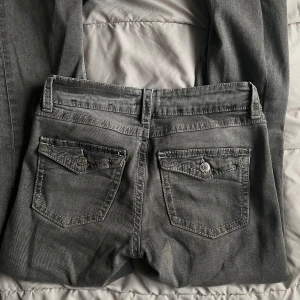 Grå jeans med bootcut - Snygga grå jeans med bootcut-stil och låg midja. De har klassiska femficksdetaljer.