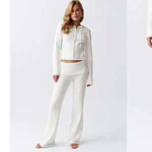 Knitted lounge trousers Gina Tricot - Snygga vita stickade byxor. Perfekta för en avslappnad och stilren look. Byxorna har en bred ribbad midja som ger extra komfort.