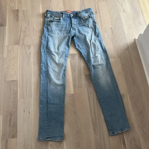 Ljusblå jeansbyxor - Snygga ljusblå jeansbyxor med en klassisk femficksdesign och knappgylf. De har en straight passform och är perfekta för en avslappnad stil. Märkeslappen syns på baksidan av midjan.