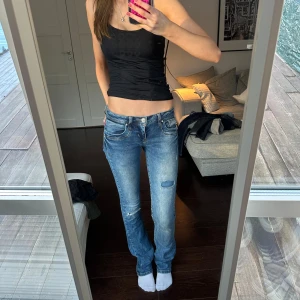Blå jeans med slitningar - Snygga blå jeans med slitningar från LTB i modell Valerie. De har en lågmidjad passform och en straight stil som ger en avslappnad look. Perfekta för en casual outfit. 💗 står ej för postens slarv eller frakt!! 