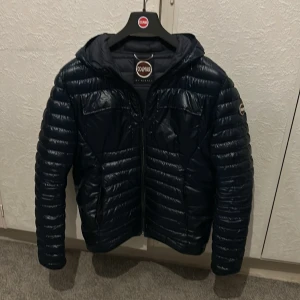 Colmar pufferjacka mörkblå glansig - Säljer en snygg mörkblå pufferjacka från Colmar. STL 52 annars STL S-M!  Den är glansig och har en stilren look som funkar till det mesta. Perfekt för dig som vill hålla stilen i vinter! Denna colmar är en unik modell som inte syns mycket på marknaden. Det är den glansiga varianten med snygga två fickor vid brösten! Kontakta mig om annat, annars för att lägga ett bud så tar vi det därifrån!