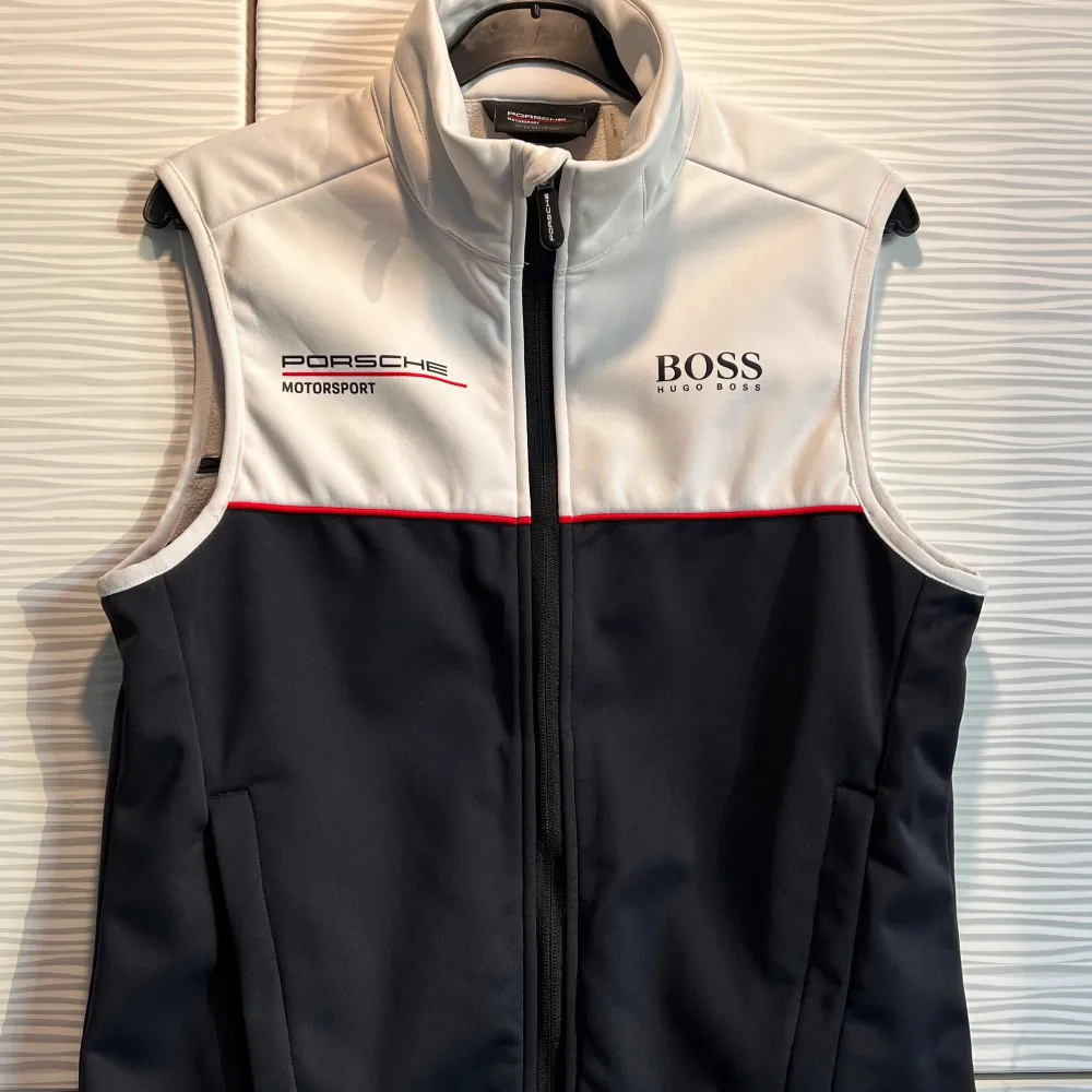 Snygg svart och vit väst från Porsche med en avtagbar duk i höger ficka, I storlek Eu Xs. Perfekt för den stilmedvetna som gillar motorsport. Skick 10/10 inga tecken på användning. Köptes för 2700 kr. Priset är inte hugget i sten och kan diskuteras! / Mvh Rivi’e Reventio. Takit.
