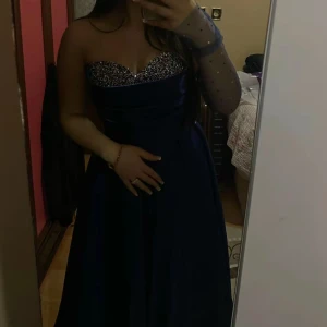 Mörkblå klänning med paljetter - Elegant mörkblå klänning med glittrig paljettöverdel och axelbandslös design. Perfekt till studentbalo❤️storlek s/m använd bara 1 gång