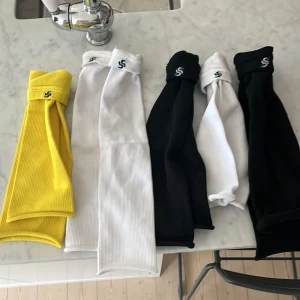 Svarta, vita och gula skillsocks  - Skillsocks, svarta, vita och gula två par av svart och vit färg och ett par gula. I nyskick och aldrig använda då de inte passade mig. Nypris 179 kr styck. Mitt pris: 150 kr för alla.