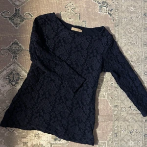 Mörkblå spetsblus från Noom - Elegant mörkblå spetsblus från Noom i storlek S. Blusen har långa ärmar och ett vackert blommigt spetsmönster som ger en sofistikerad look. Perfekt för att lyfta vilken outfit som helst. 🌟