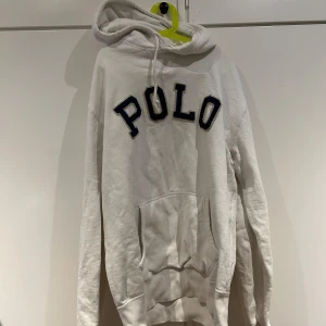 Vit hoodie från Polo Ralph Lauren - Säljer en vit hoodie från Polo Ralph Lauren med stor POLO-text på framsidan.  