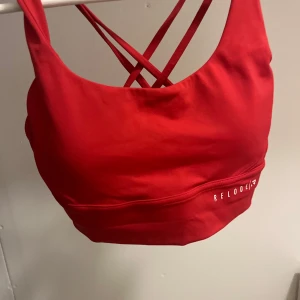 Röd sporttopp från Relode - Snygg röd sporttopp från Relode med korsade axelband i ryggen. Den är oanvänd 