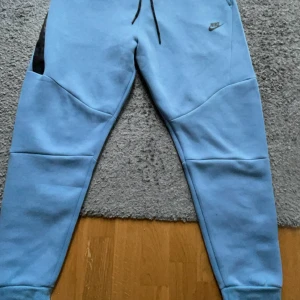 Blå mjukisbyxor från Nike - Nike tech byxor i storlek L, Jag tycker att dom byxorna är för stora på mig och jag vill sälja dom. Har använt dom en gång bara. Det är bara att fråga om ni undrar något.