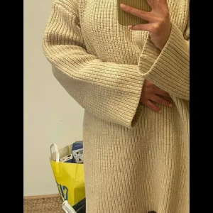 Beige stickad klänning från ASOS  - Säljer en mysig beige stickad klänning med långa ärmar och en avslappnad passform. Perfekt för kyliga dagar med sin mjuka och bekväma design. Tröjan har en enkel och stilren passform. 