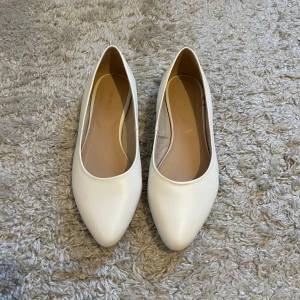 Vita ballerinaskor från Anna Field - Snygga vita ballerinaskor från Anna Field med spetsig tå. Perfekta för en stilren look. Skorna är tillverkade i syntetmaterial och har en klassisk design som passar till många olika outfits. Skriv för fler bilder eller funderingar💕