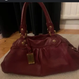 SÖKER!!! Vinröd handväska med detaljer - Söker vinröd/burgundy röd handväska från Marcjacobs!! Gärna lite större väska och att det går att mötas upp i Stockholm. Hör av er om ni säljer❤️