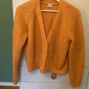 Orange stickad kofta från Lindex - Säljer en mysig orange stickad kofta från Lindex. Storlek 146/152 men passar mig som har 158/xxs