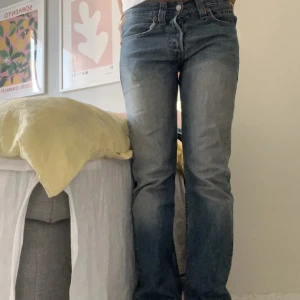 Blå jeans med bootcut - Snygga blå jeans med bootcut-stil och klassisk femficksdesign. De har en lätt tvättad look och är perfekta för en avslappnad stil. Passformen är normal och de har en traditionell dragkedja och knapp framtill.