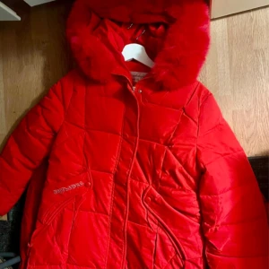 Röd dunjacka med pälskrage - Snygg röd dunjacka från Whitworks med en fluffig pälskrage. Jackan har en quiltad design och dragkedja framtill. Perfekt för kalla dagar med stil.