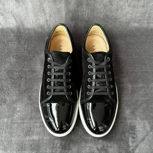 Svarta lanvin skor med glans - Snygga svarta sneakers från LANVIN med en kombination av mocka och lackdetaljer. Skorna har en vit sula och klassisk snörning. Perfekta för en stilren look.