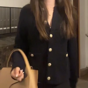 Mörkblå stickad kofta med guldknappar - Snygg mörkblå kofta från HM med guldnalppar. Jättebra skick, endast använd några gånger 